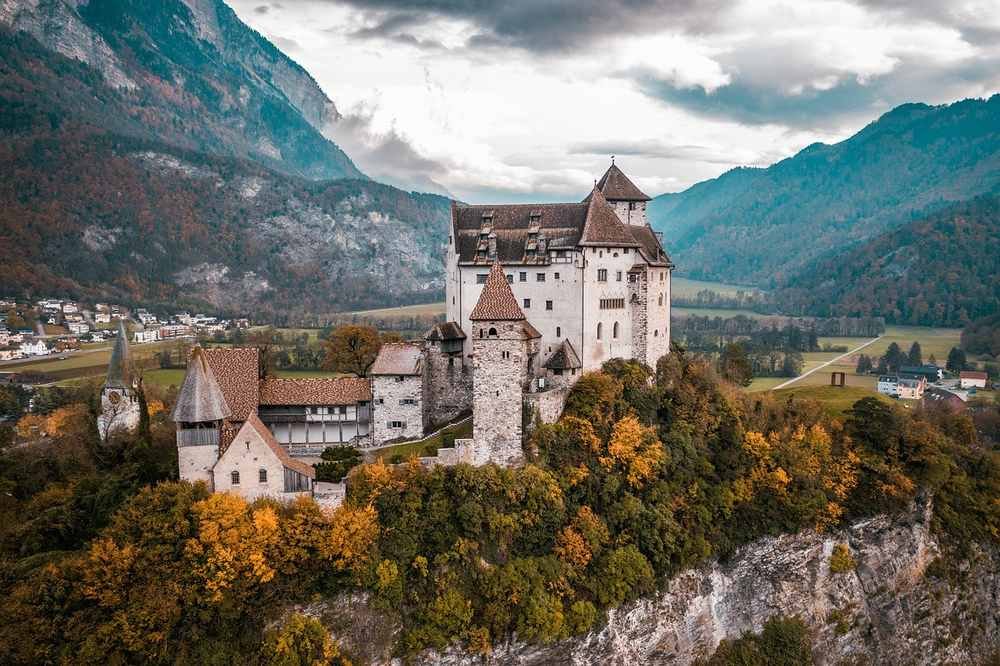 Un château fortifié perché sur colline au milieu d'un paysage montagneux